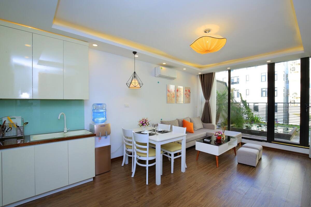A modern living room with a dining area, large windows, and a view of the city.
