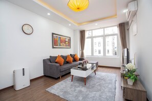 Exclusief appartement, uitzicht op de stad | Woonruimte | Een 50-inch televisie met kabelzenders en een open haard