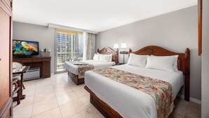 Une chambre d’hôtel avec deux lits, un bureau avec une télévision et une vue sur le paysage urbain grâce à de grandes fenêtres.