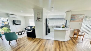 A modern living space with a kitchen, dining area, and seating.