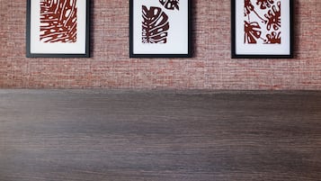 Three framed abstract art pieces on a textured wall above a wooden floor.