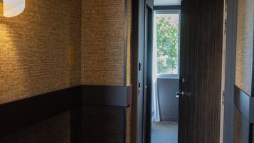 Een gang met een tapijtvloer, houten wanden en een deur naar een balkon.