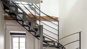A modern staircase with metal railings and wooden steps, leading to a bedroom with a window. - Notre-Dame Family Retreat - Authentic Paris Duplex (Paris)