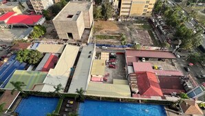 A hotel with a large outdoor swimming pool, multiple buildings, and a parking area. - Unistay Coast Res R31 with Bal-Sunset Vw (Pasay)