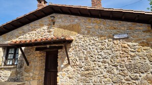 Edifici de pedra amb teulada de teules, porta de fusta i un rètol que diu "CEREZAL 3".