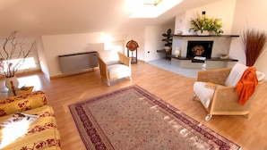A spacious living room with a fireplace, a sofa, a chair, and a coffee table. - hotel san gerolamo (Vercurago)