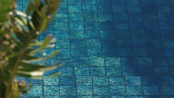 Ein Pool mit klarem, blauen Wasser und gefliestem Boden.
