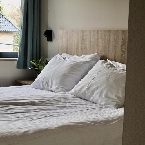 Comfortable hotel room next to Moeke Mooren, featuring modern amenities and a welcoming atmosphere for a relaxing stay.