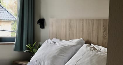 Comfortable hotel room next to Moeke Mooren, featuring modern amenities and a welcoming atmosphere for a relaxing stay.