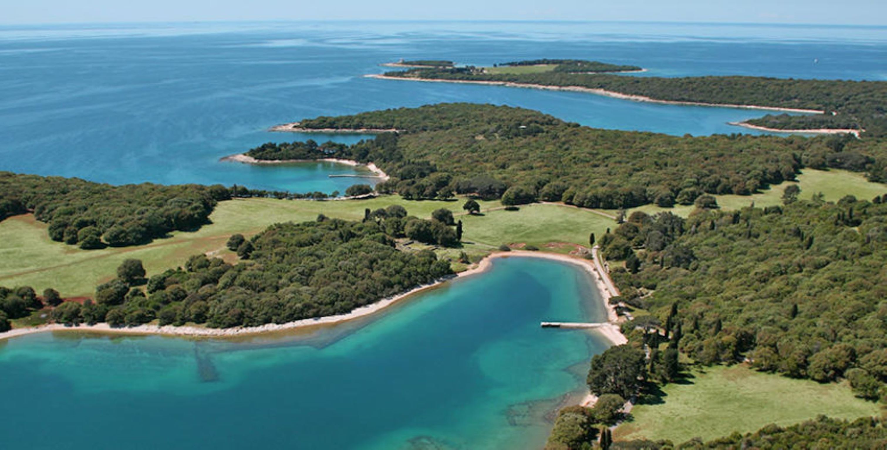Vue aérienne d’une zone côtière avec de nombreuses petites îles et une grande baie.