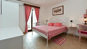 A bedroom with a bed, a desk, a chair, a lamp, and a window with curtains. - Charming accommodation with shared pool Beahost (Peroj)