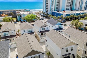 Un quartier résidentiel comprenant des maisons, un parking et un hôtel avec piscine et vue sur la plage.