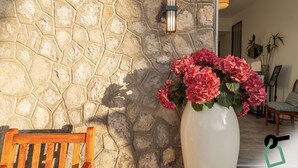 A stone wall with a wooden bench and a white vase with pink flowers. - Hotiday Room Collection - Massa Lubrense (Massa Lubrense)
