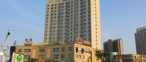Un edificio de varios pisos con locales comerciales en la planta baja, incluyendo un karaoke.