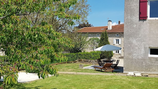 A stone house with a red shutter, a lawn, and a patio with outdoor furniture. - Charming cottage in the heart of the Vosges (Removille)