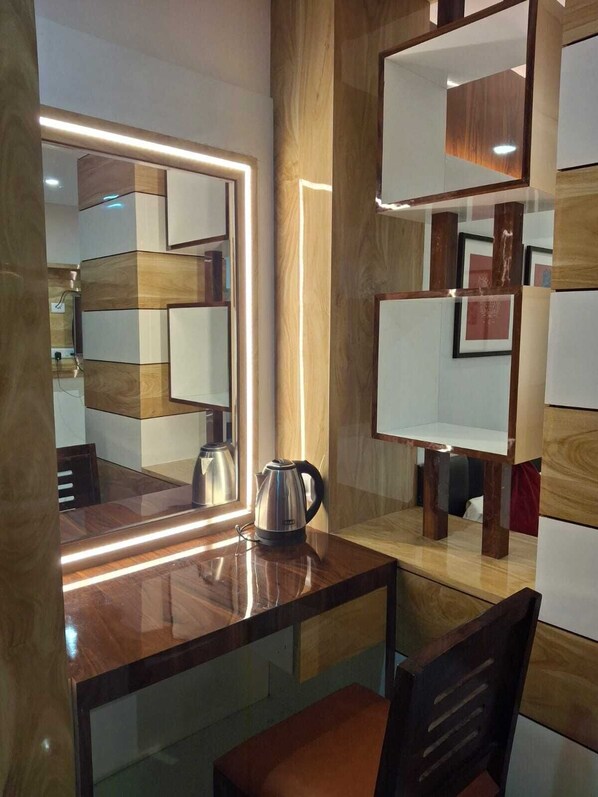A modern kitchen with a wooden countertop, a kettle, and a mirror with illuminated edges. - Hotel Sapphire Inn (Gorakhpur)