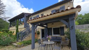 Une maison dotée d’un patio couvert, d’un escalier et d’un espace salon extérieur.