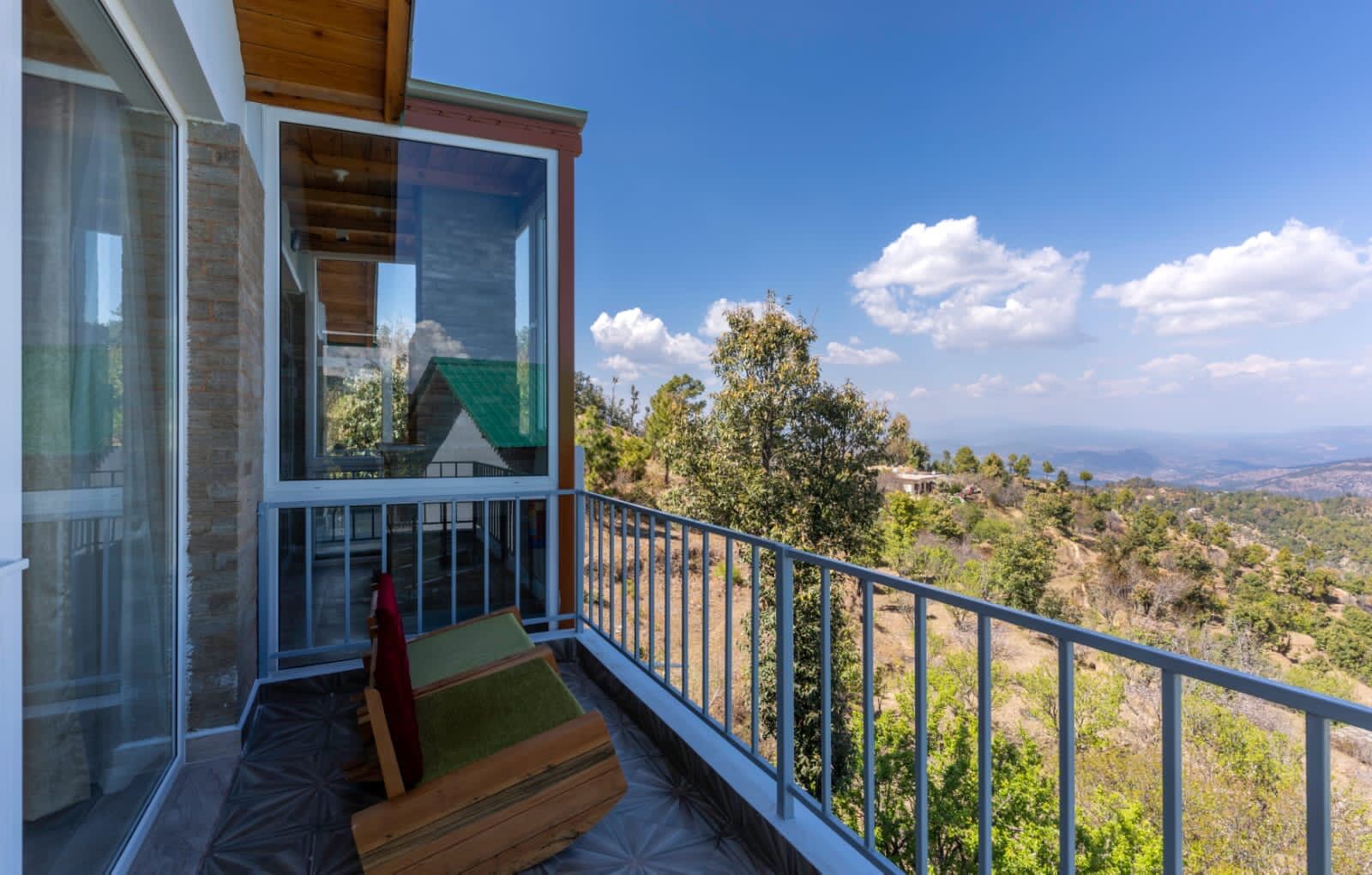 Un balcón moderno con vistas despejadas a un paisaje montañoso.