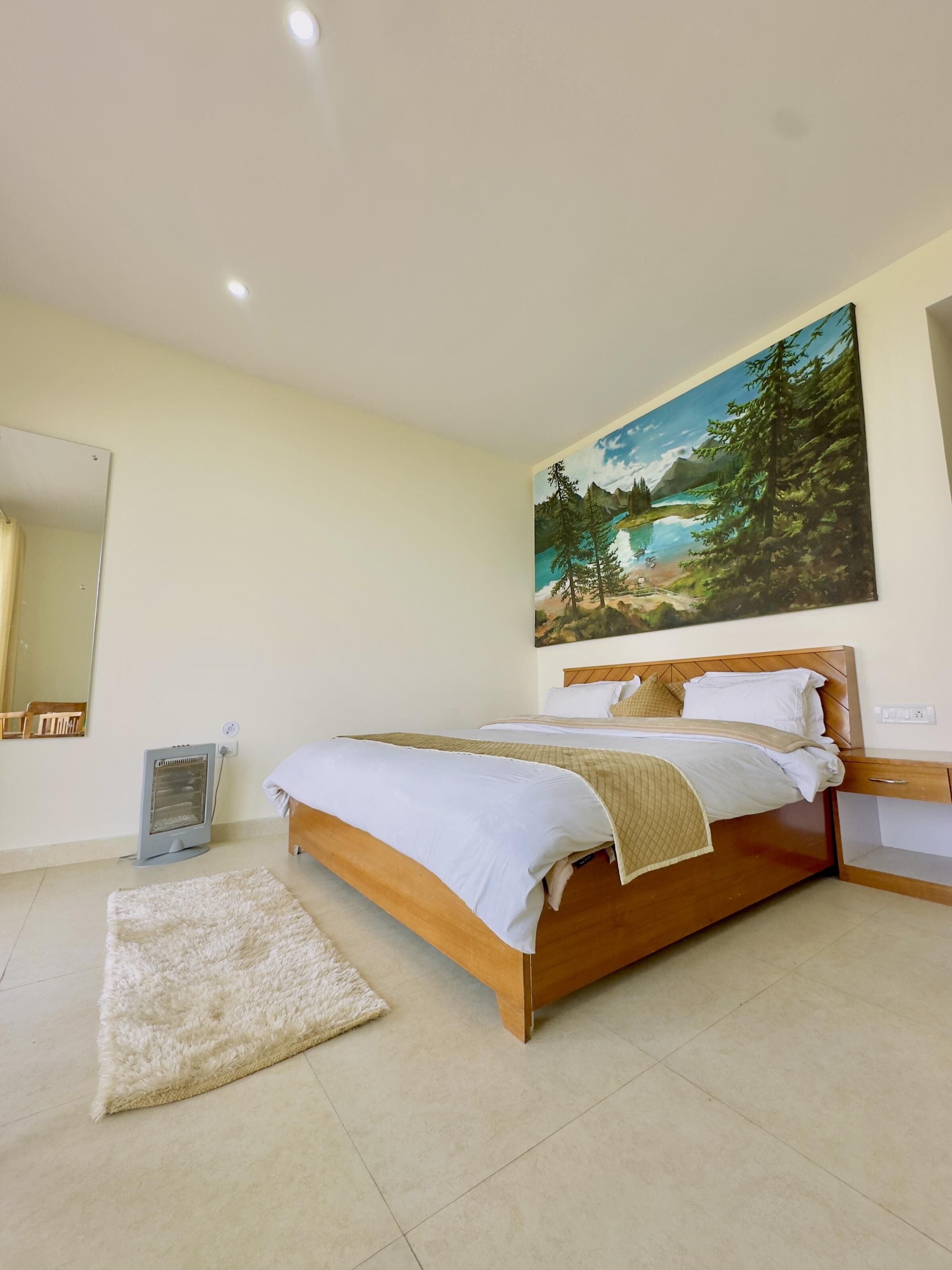 Ein Schlafzimmer mit einem hölzernen Bett, einem großen Landschaftsbild, einem Heizkörper und einem Teppich.