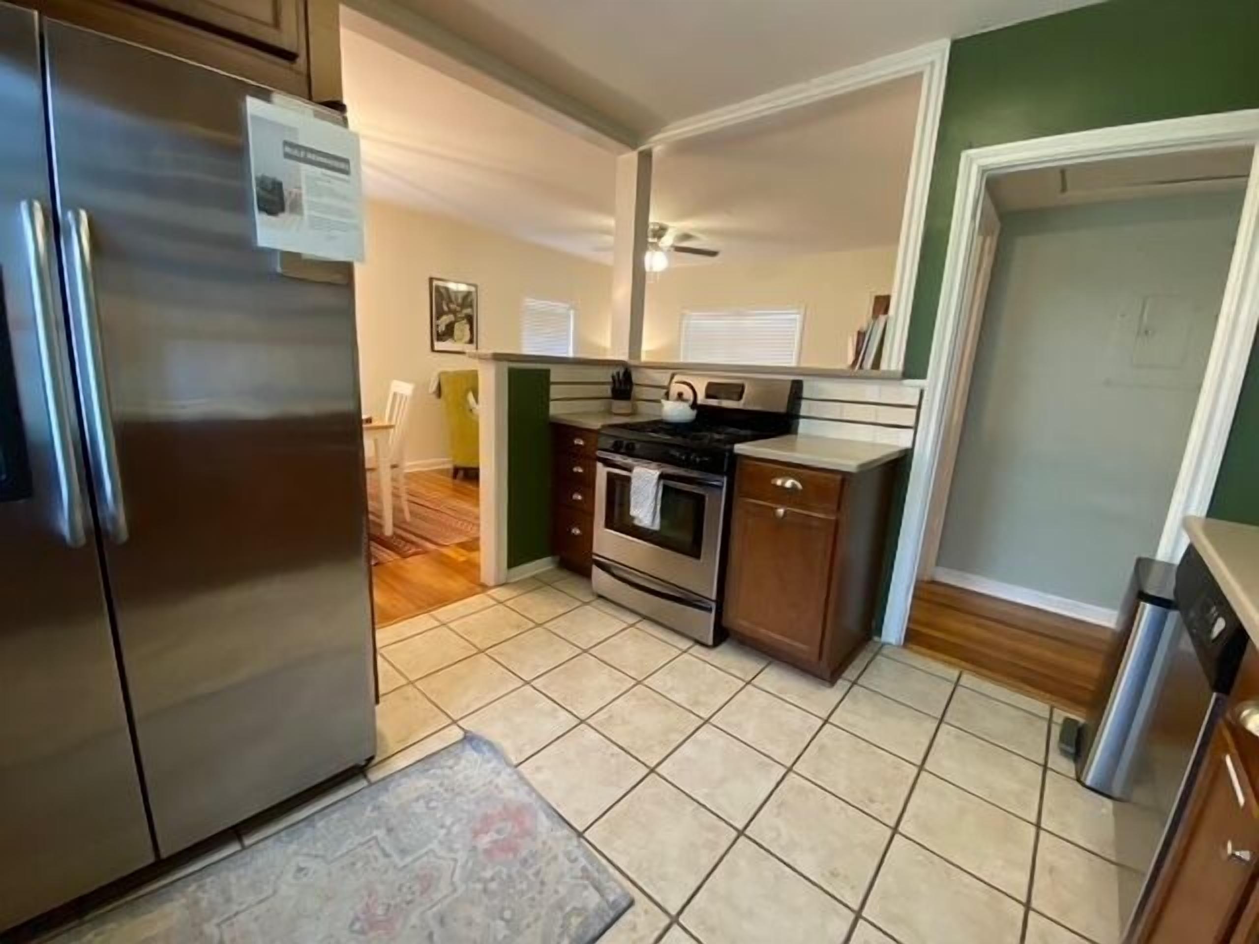 A compact kitchen with a refrigerator, stove, oven, and a small cabinet.