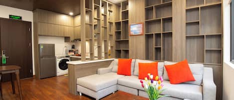 Departamento Deluxe, vista a la ciudad | Área de sala de estar | Televisión de pantalla plana de 50 pulgadas con canales por cable