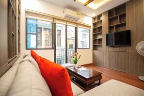 Departamento Deluxe, vista a la ciudad | Área de sala de estar | Televisión de pantalla plana de 50 pulgadas con canales por cable 