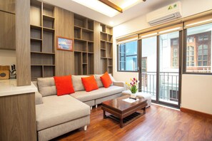 Departamento Deluxe, vista a la ciudad | Área de sala de estar | Televisión de pantalla plana de 50 pulgadas con canales por cable 