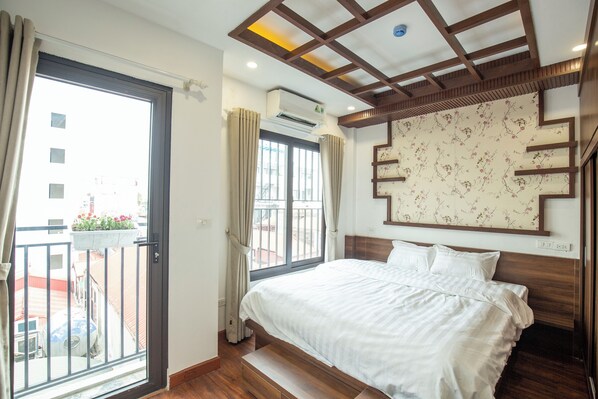 Une chambre d’hôtel avec un lit, un balcon et une vue sur l’extérieur.