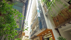 A narrow alleyway between buildings with balconies, some with plants. - Sumitomo7- Linh Lang Serviced Apartment (Hanoi)