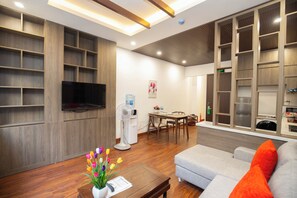 Departamento Deluxe, vista a la ciudad | Área de sala de estar | Televisión de pantalla plana de 50 pulgadas con canales por cable 