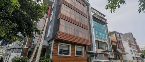 A multi-story building with a modern design, featuring a mix of glass and wood paneling.