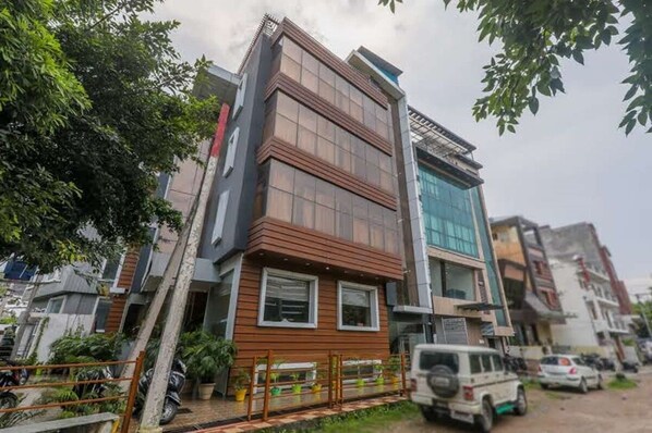 A multi-story building with a modern design, featuring a mix of glass and wood paneling. - Hotel Surya Grand (Lucknow)