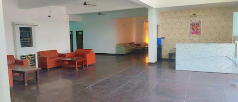 Eine großzügige Lobby mit Empfangsschalter, Sitzgelegenheiten und einer Wand mit Musterdesign.