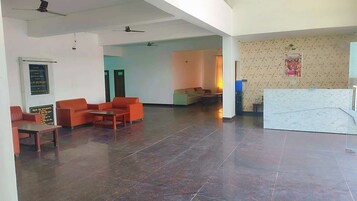 A spacious lobby with a reception desk, seating area, and a patterned wall.