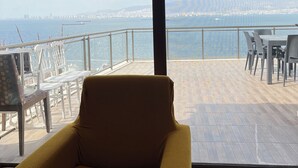 A modern room with a large window overlooking a cityscape and the sea. - Stay with the best view of Izmir (İzmir)