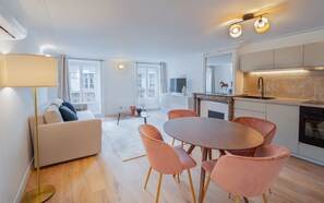 A modern apartment with a living area, dining space, and kitchen. - Madeleine Opéra - One Bedroom Deluxe in Paris (Paris)