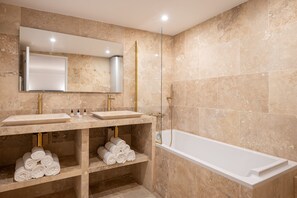 A modern bathroom with two sinks, a large mirror, a glass-enclosed shower, and a white bathtub. - Madeleine Opéra - Two Bedroom Deluxe in Paris (Paris)