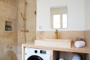 A bathroom with a washing machine, a sink, a mirror, and a shower. - Madeleine Opéra - Excellent One Bedroom in Paris (Paris)