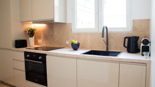A modern kitchen with a built-in dishwasher, oven, and a double sink. - Madeleine Opéra - Excellent One Bedroom in Paris (Paris)