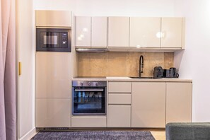 A compact kitchen with a built-in oven, microwave, and a coffee maker on the countertop. - Madeleine Opera - Very nice Apartment in Paris (Paris)