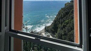 A window with a view of the ocean and a cliff. - Hotiday Arenzano Pineta (Arenzano)