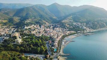 Vista aérea de una ciudad costera con una iglesia destacada, una zona urbana densa y una playa.