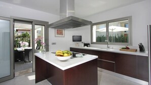 Una cocina moderna con una isla central, un ventanal y vistas al exterior.
