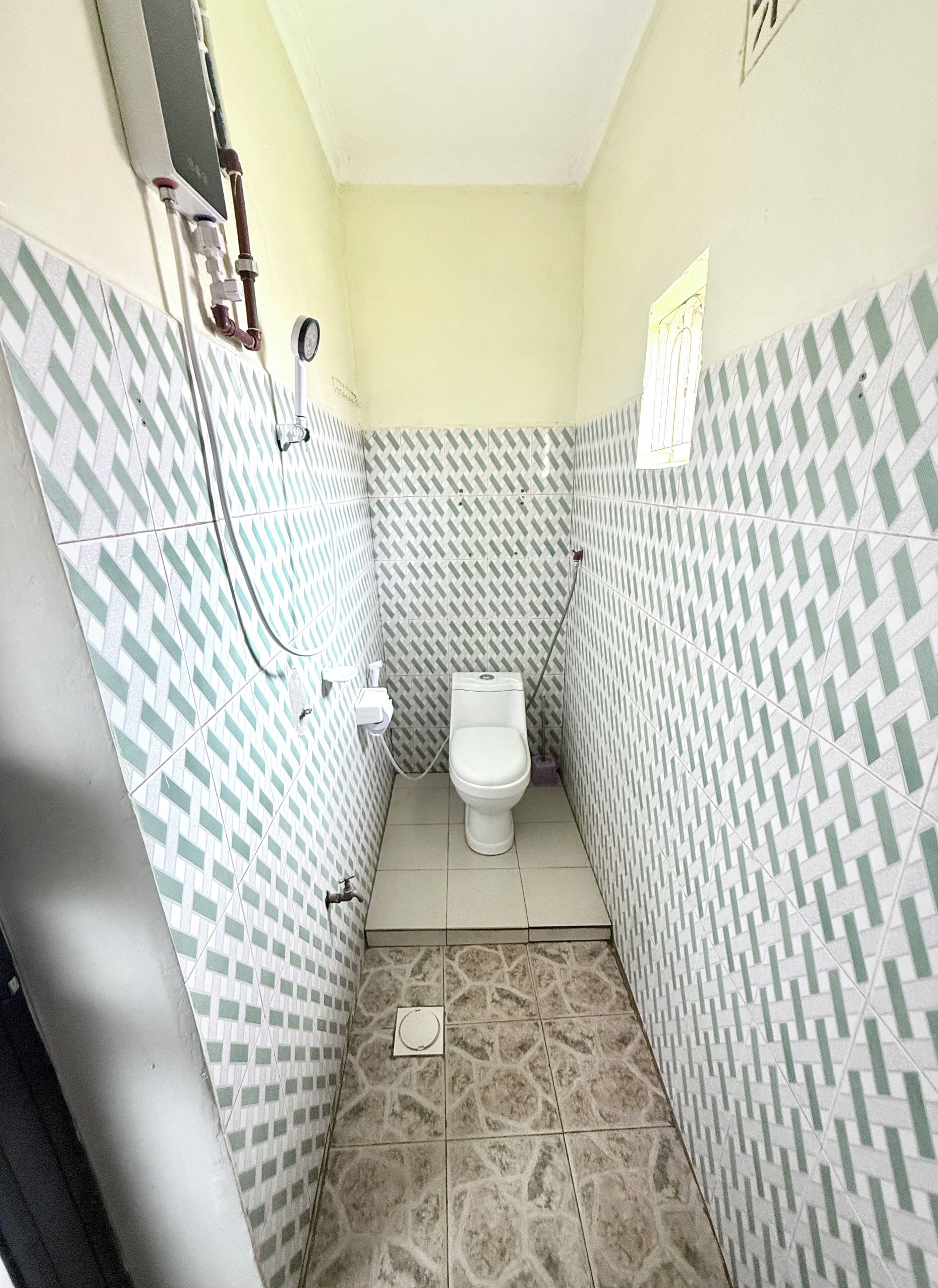 A small bathroom with a toilet, a shower, and a sink.