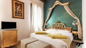 A bedroom with a large bed, a television on a wooden cabinet, and a green accent wall. - Hotiday Room Collection - Dolo (Dolo)