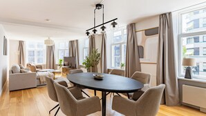 A modern living room with a round table, sofas, and a TV. - Regent 15 - Bright 1 Bdr Apt Right in the Centre of Copenhagen (Copenhagen)