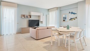 A modern living room with a sofa, TV, dining table, and chairs. - Levante, amazing modern house in Viareggio city (Viareggio)