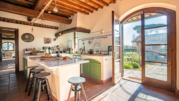 A spacious kitchen with a large island, green cabinets, and a view through an open door. - Podere La Troscia is an enchanting Rustic Villa in the Versilia countryside on the Tuscan coast with Garden and Private Pool; the owners love to share this wonderful place with guests from all over the world who intend to visit the North of Tuscany, the  (Piano di Mommio)