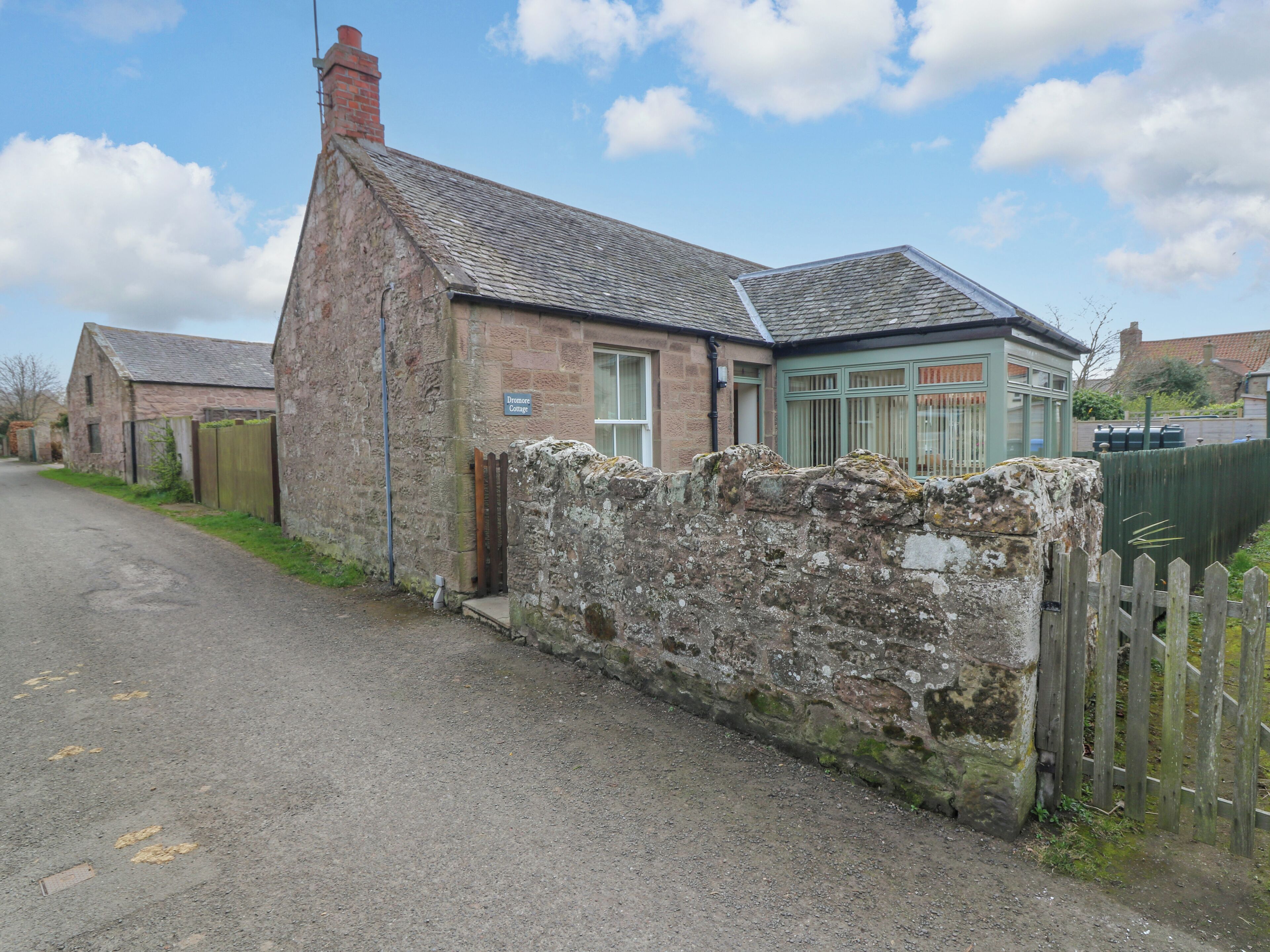 A traditional stone cottage with a sign reading "Dremore Cottage."