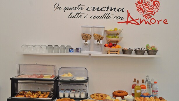 A buffet setup with various food items and beverages, including pastries, fruits, and condiments. - Hotiday Lecce Gianmarti Suite (Lecce)